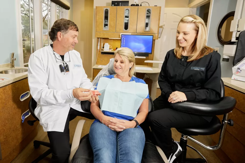 Dentist and assistant educating patient